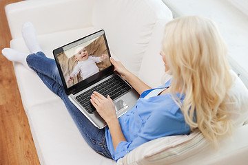 Image showing mother watching baby by video monitor on laptop