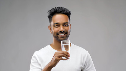 Image showing happy young indian man drinking water from glass