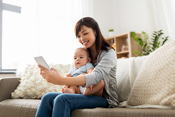 Image showing happy mother with baby son taking selfie at home