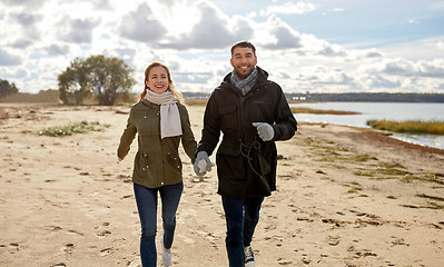 Image showing couple walking along autumn beach