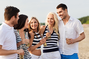 Image showing happy friends drinking non alcoholic beer on beach