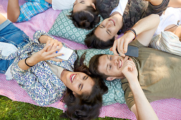 Image showing friends with smartphones chilling at summer park