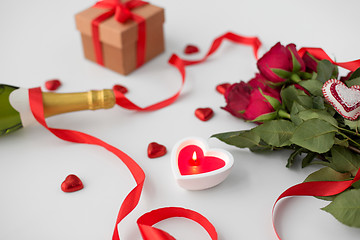 Image showing close up of champagne, gift, candies and red roses