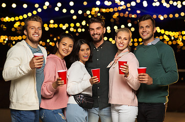Image showing friends with party cups on rooftop at night