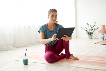 Image showing woman with tablet pc and drink at yoga studio