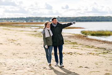 Image showing couple walking along autumn beach