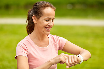 Image showing woman with smart watch or fitness tracker in park