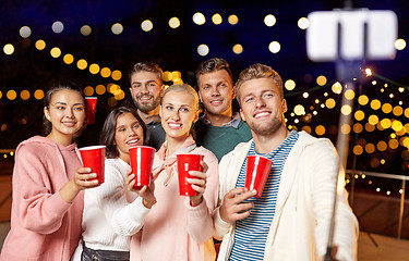 Image showing friends with drinks taking selfie at rooftop party