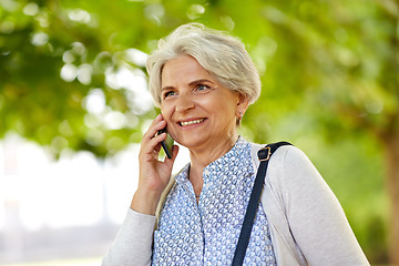 Image showing senior woman calling on smartphone in summer park