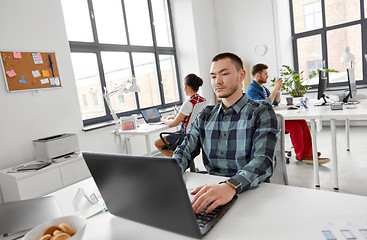 Image showing creative man with laptop working at office