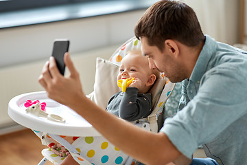 Image showing father with baby daughter taking selfie at home