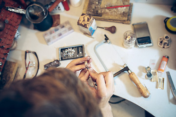 Image showing Different goldsmiths tools on the jewelry workplace. Jeweler at work in jewelry.