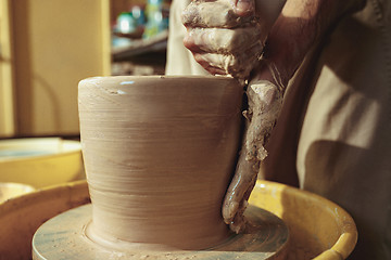 Image showing Creating a jar or vase of white clay close-up. Master crock.