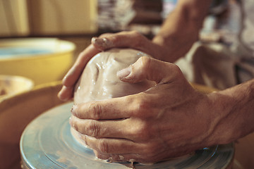 Image showing Creating a jar or vase of white clay close-up. Master crock.