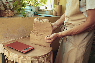 Image showing Creating a jar or vase of white clay close-up. Master crock.