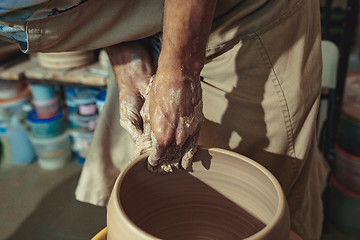 Image showing Creating a jar or vase of white clay close-up. Master crock.