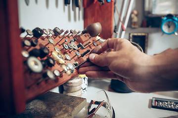 Image showing Different goldsmiths tools on the jewelry workplace. Jeweler at work in jewelry.