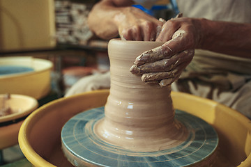 Image showing Creating a jar or vase of white clay close-up. Master crock.