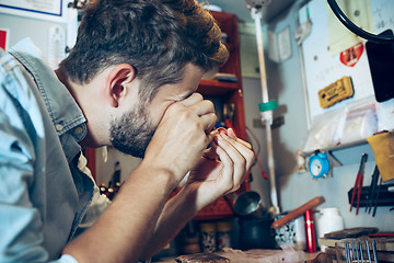 Image showing Different goldsmiths tools on the jewelry workplace. Jeweler at work in jewelry.