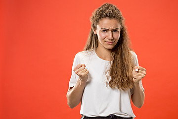 Image showing Beautiful woman looking suprised and bewildered isolated on red