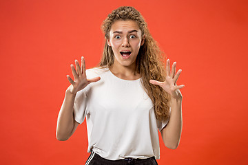 Image showing Beautiful woman looking suprised isolated on orange