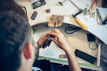 Image showing Different goldsmiths tools on the jewelry workplace. Jeweler at work in jewelry.