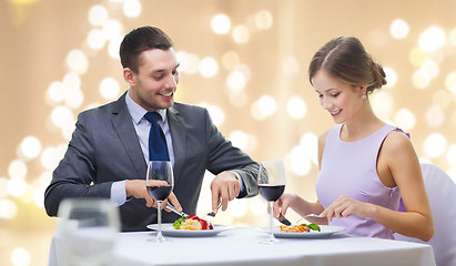 Image showing smiling couple eating appetizers at restaurant