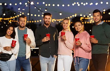 Image showing friends with party cups on rooftop at night