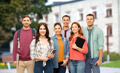 Image showing group of smiling students with books over campus