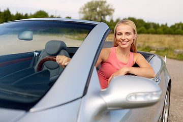 Image showing happy young woman driving convertible car