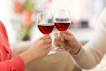 Image showing hands of couple clinking red wine glasses