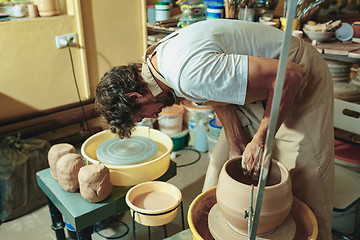 Image showing Creating a jar or vase of white clay close-up. Master crock.