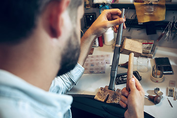 Image showing Different goldsmiths tools on the jewelry workplace. Jeweler at work in jewelry.