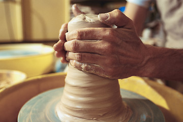 Image showing Creating a jar or vase of white clay close-up. Master crock.