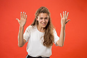 Image showing Beautiful woman looking suprised and bewildered isolated on red