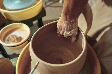 Image showing Creating a jar or vase of white clay close-up. Master crock.