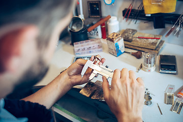 Image showing Different goldsmiths tools on the jewelry workplace. Jeweler at work in jewelry.