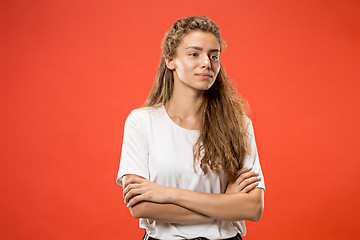 Image showing The happy woman standing and smiling against red background.