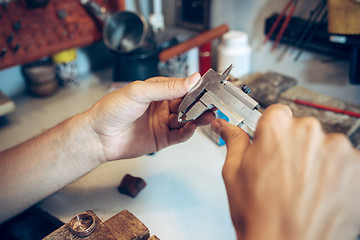 Image showing Different goldsmiths tools on the jewelry workplace. Jeweler at work in jewelry.