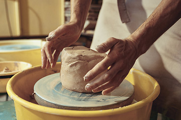 Image showing Creating a jar or vase of white clay close-up. Master crock.