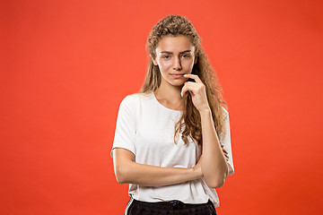 Image showing The happy woman standing and smiling against red background.