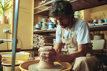 Image showing Creating a jar or vase of white clay close-up. Master crock.