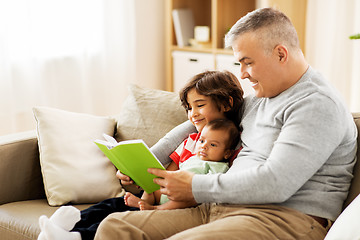 Image showing happy father with sons reading book at home