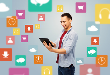 Image showing happy young man with tablet over media icons