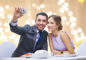 Image showing happy couple taking selfie at sushi restaurant