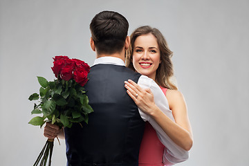 Image showing woman with engagement ring and roses hugging man