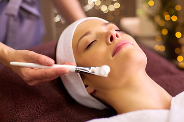 Image showing beautician applying facial mask to woman at spa