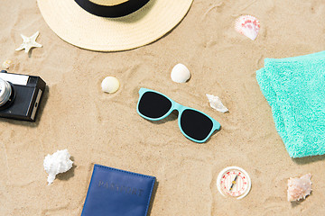 Image showing camera, passport, sunglasses and hat on beach sand