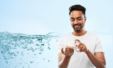 Image showing happy indian man with perfume over blue background