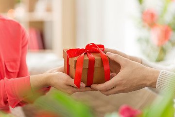 Image showing close up of male and female hands with gift box